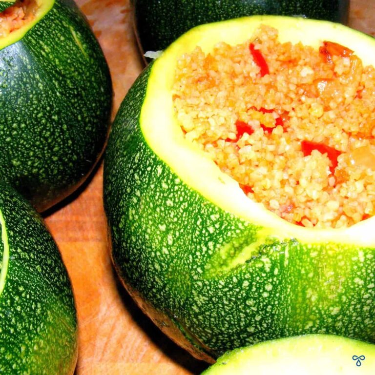 Globe-shaped green squash, hollowed oıut and stuffed with a bulgur wheat filling. Some have lids on.