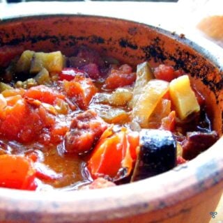 Casseroled vegetables in a terracotta casserole pot.