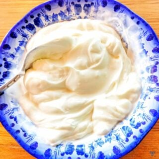 Creamy natural yoghurt in a blue and white bowl.