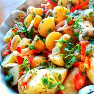 Turkish potato salad with slices of spring onions, red peppers and chopped parsley leaves