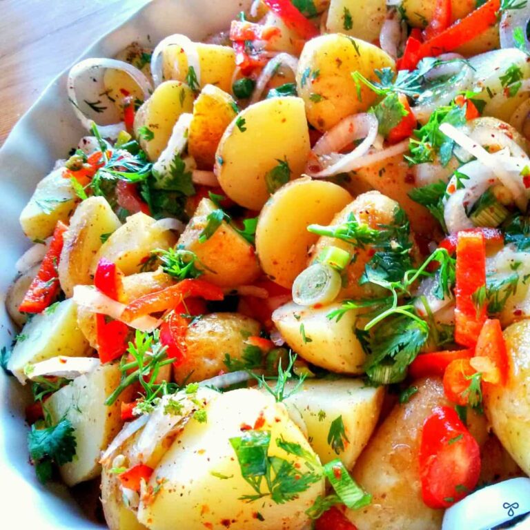 Turkish potato salad with slices of spring onions, red peppers and chopped parsley leaves