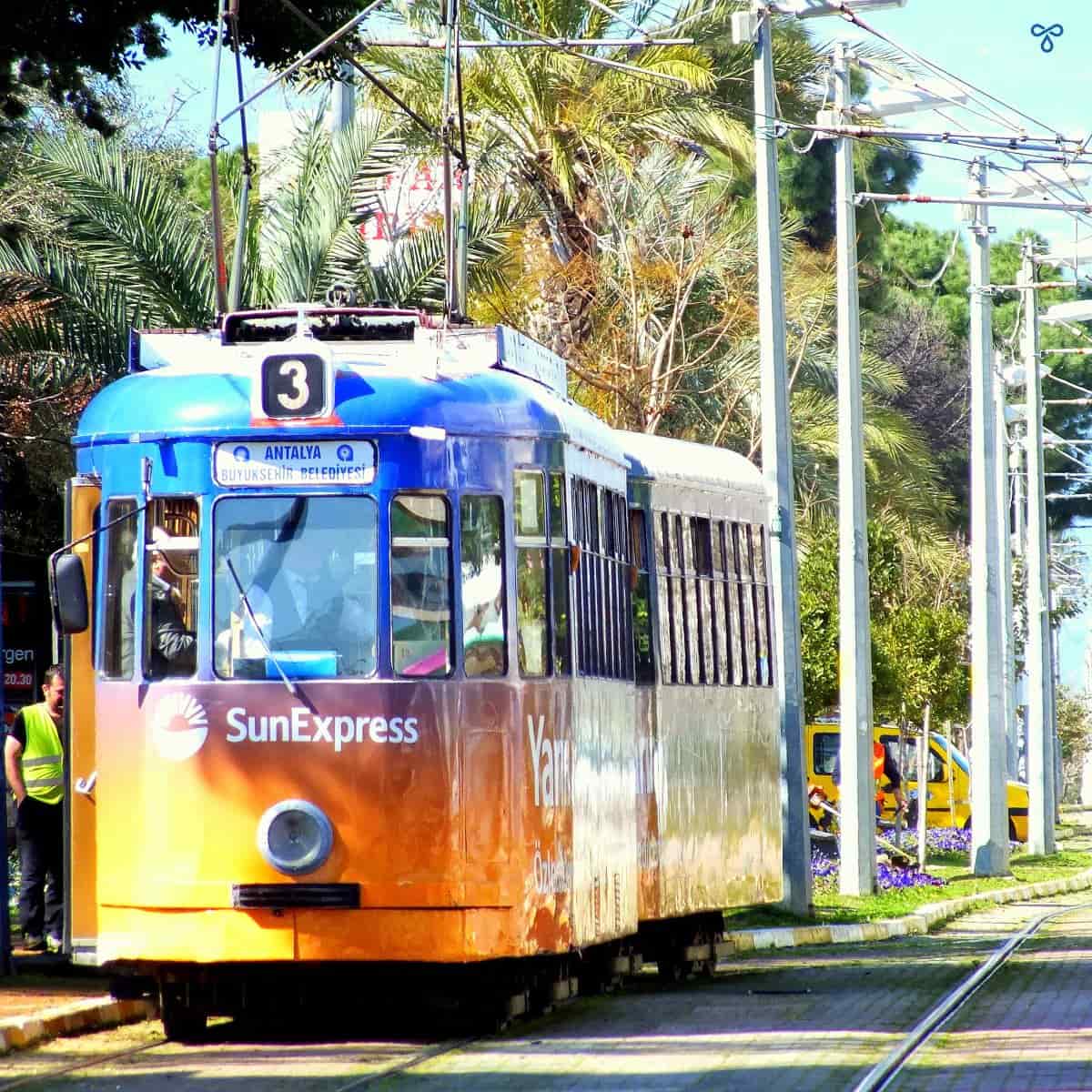 A colourful historic tram in Antalya. Sun Express is written across the front.