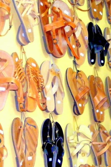 Rows of traditional Greek handmade leather sandals hanging from a wall