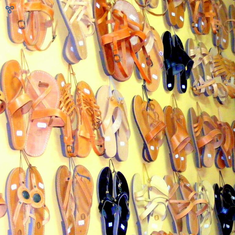 Rows of traditional Greek handmade leather sandals hanging from a wall