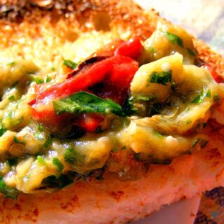 Close up of aubergine salad on top of a slice of toast