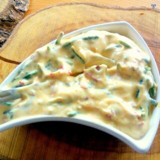 A conch-shaped bowl with a yoghurt dip. The dip contains chopped samphire.