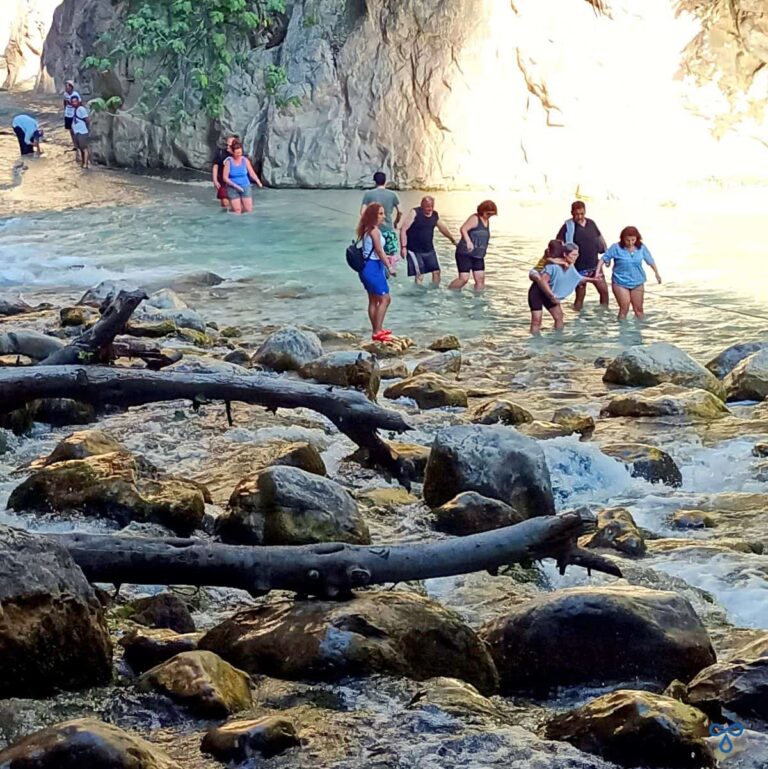 People crossing the rapids at Saklıkent Gorge to continue walking the route.