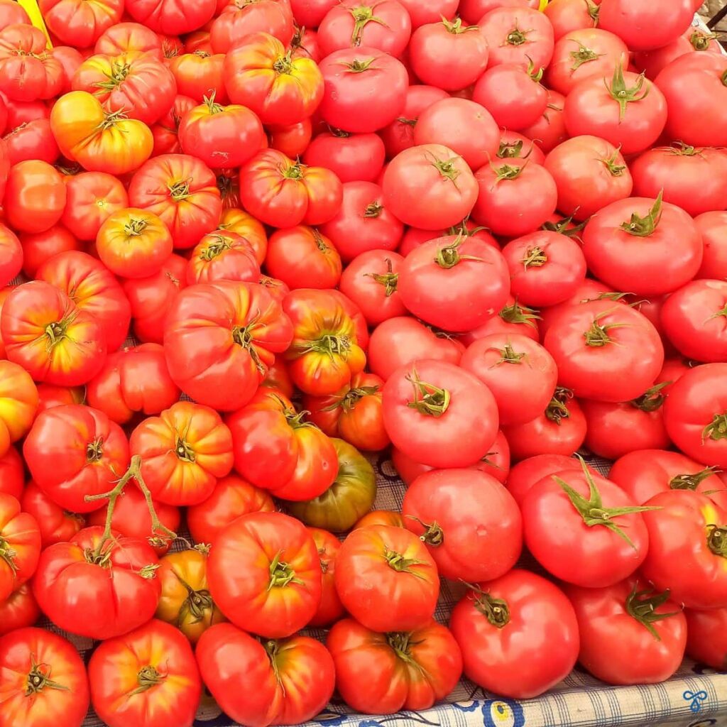 A close up shot of tomatoes on a market stall. There are two varieties; Hierloom and Pembe (Pink) Domates.