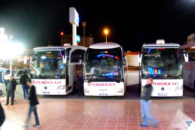 Three white intercity buses at a service station in Turkey ,n the earşy hours of the morning.