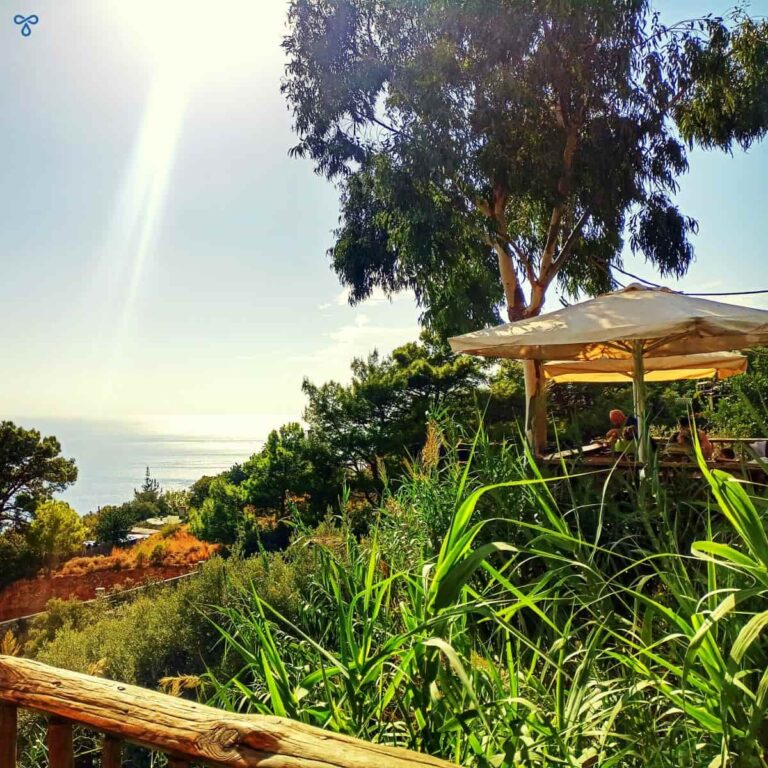 Wooden köşk seating set amongst natural greenery and overlooking the sea far below