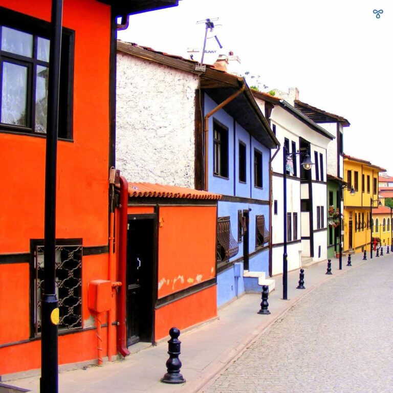 Looking down a row of terraced houses, painted in different colours