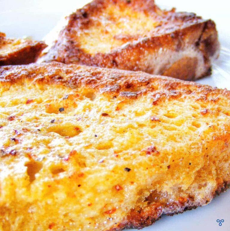 A close up of fried eggy bread topped with chilli.