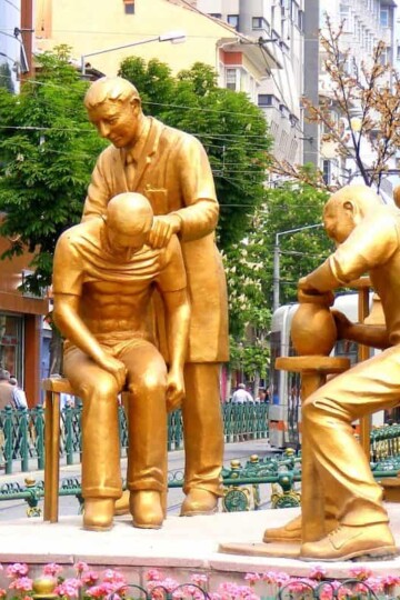 A bronze sculpture showing people of different professions. A footballer, doctor and potter.