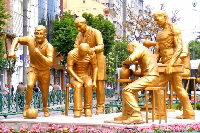 A bronze sculpture showing people of different professions. A footballer, doctor and potter.
