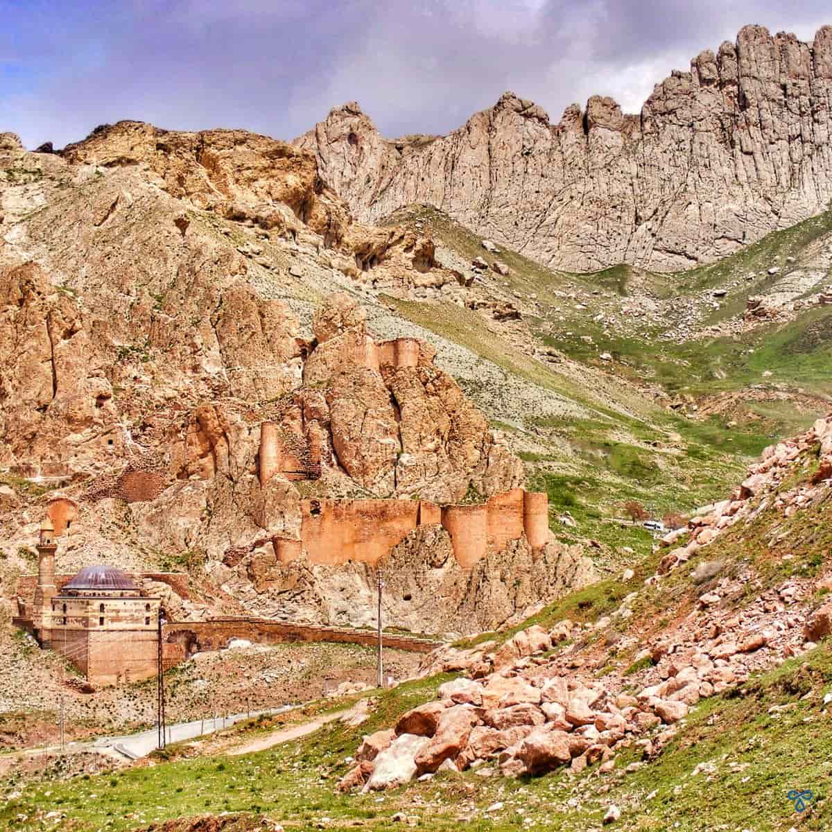 Ancşent castle walls and an old mosque built into the craggy mountainside in Doğubeyazıt.