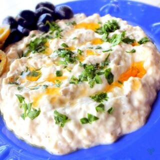 A serving of baba ganoush yoghurt and aubergine salad. Jalapeno and black olives are on the side.