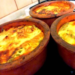 Three terracotta bowls filled with pasta bake.