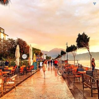 A view along Çalış Beach Promenade after the rain has stopped. Tables and chairs line each side f the promenade.