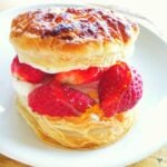 A circle of puff pastry cut in half through the middle and filled with strawberries drizzled with honey
