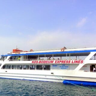 A small white passenger ferry with Kos-Bodrum Express Lines written in red letters on the side.