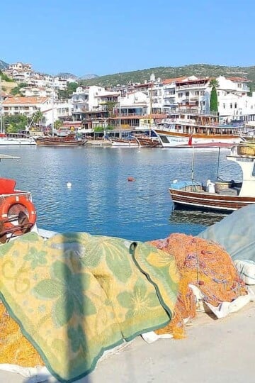 small red and white fishing boats moored in Datça harbour. Hotels and tour boats are in the background.