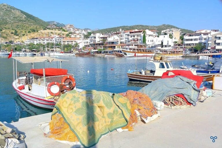 small red and white fishing boats moored in Datça harbour. Hotels and tour boats are in the background.