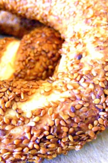 Close up of a section of a simit bread ring covered with sesame seeds