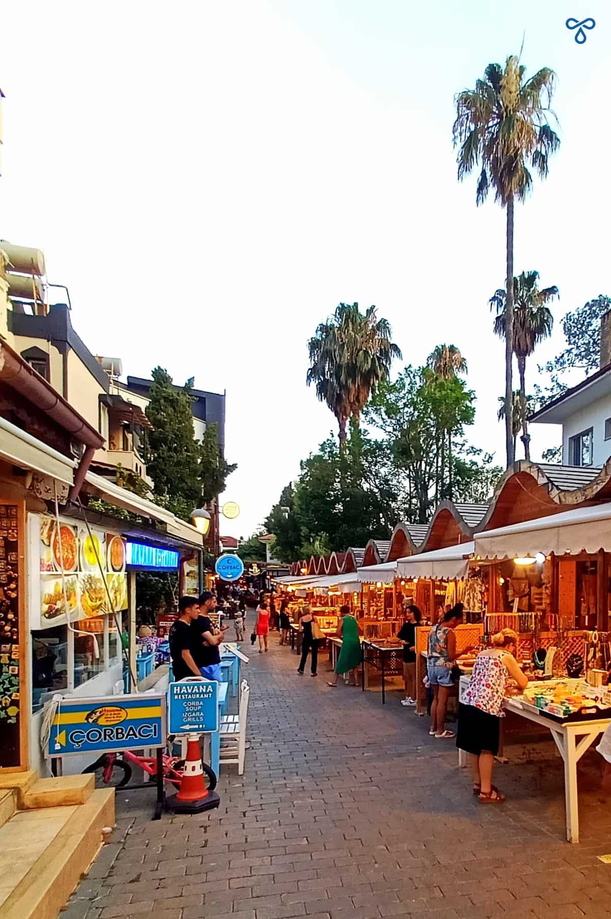 A cobbled pedestrianised street with night market stalls selling artisan goods.