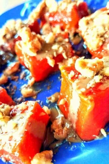 Chunks of pumpkin dessert topped with tahini and crushed walnuts