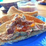 Triangular slices of toast; the top slice spread with chicken liver pate and topped with relish.