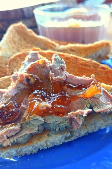 Triangular slices of toast; the top slice spread with chicken liver pate and topped with relish.