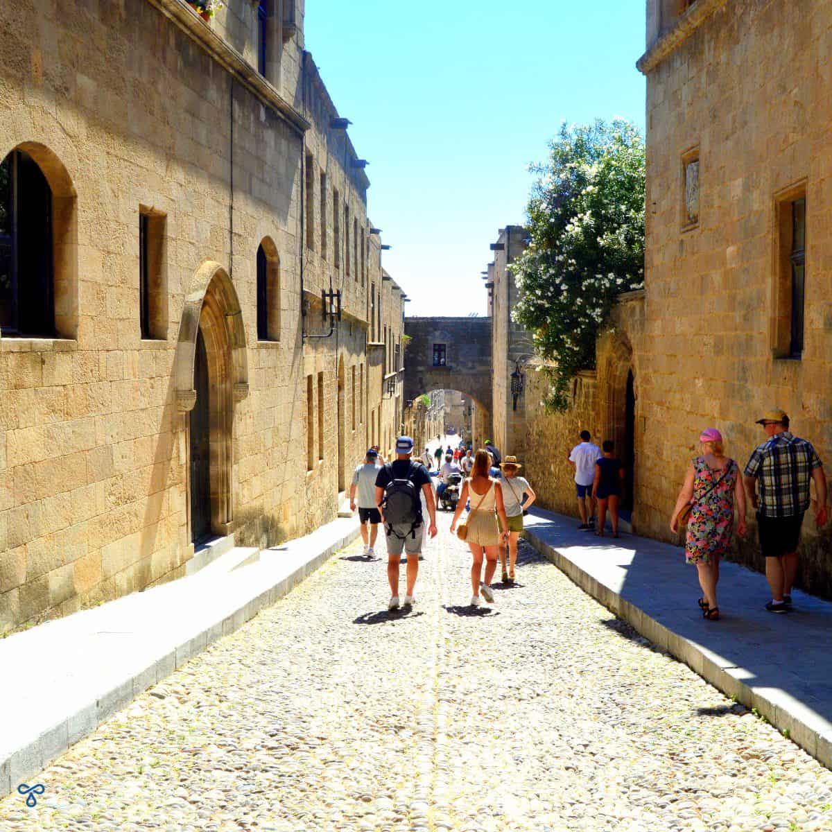 Looking downhill along the cobbled Street of the Knights. The terraced stone buildings line either side of the street.
