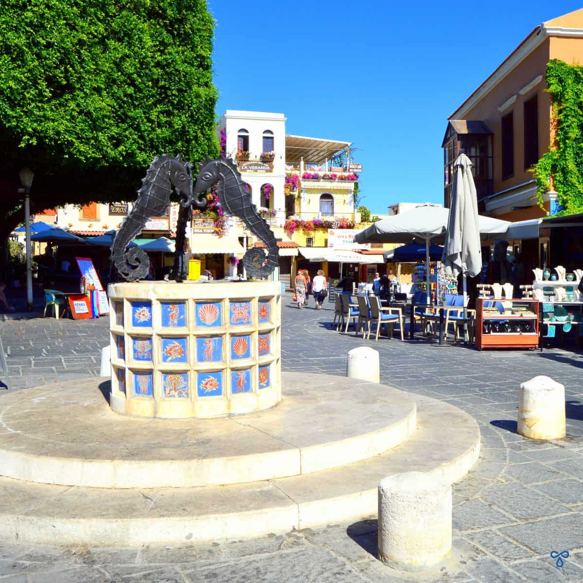 Seahorse Square in Rhodes Old Town. A decorative plinth with three black seahorses on top.