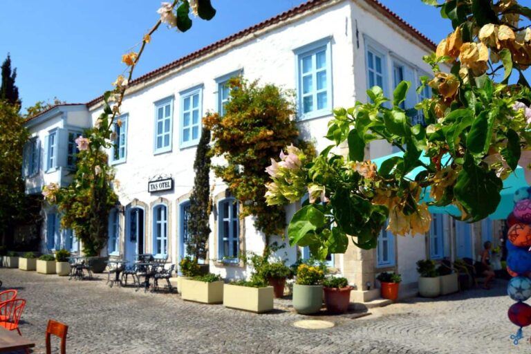 A whitewashed stone hotel with blue shutters
