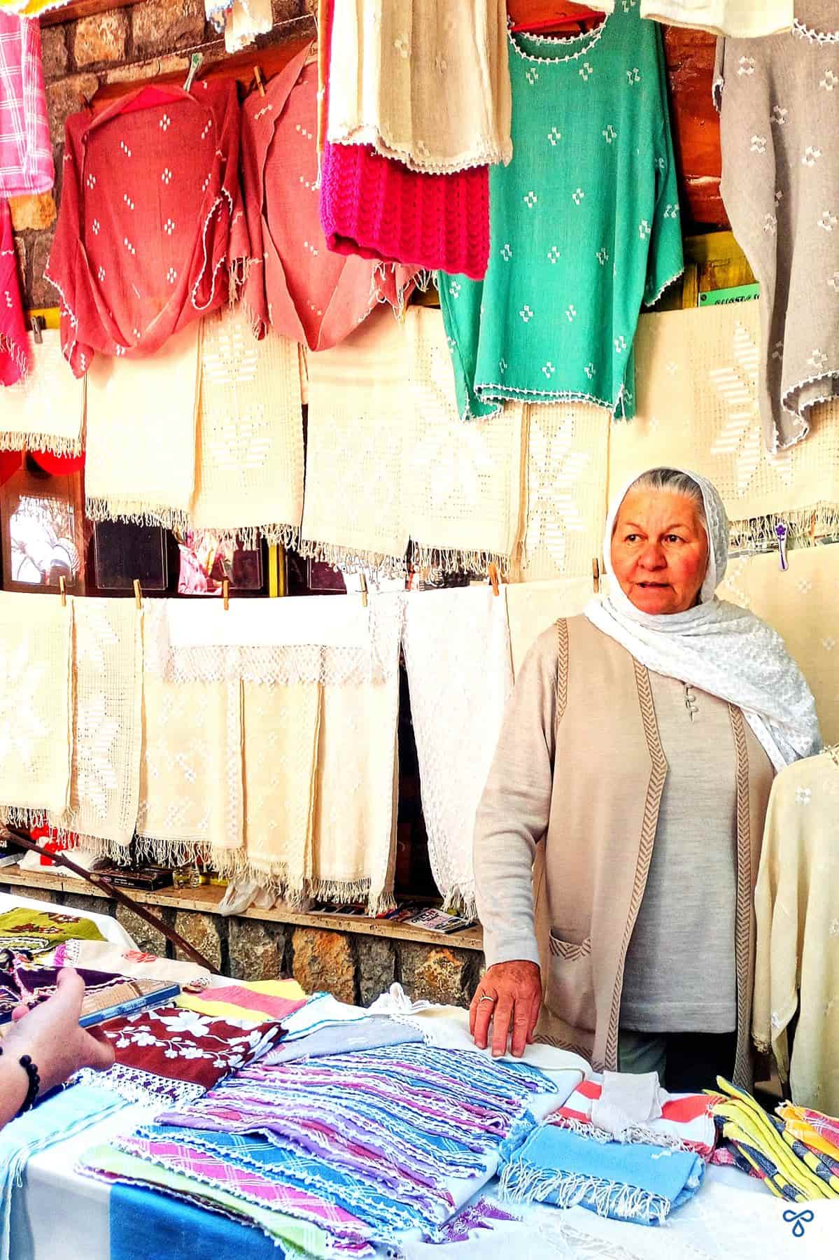 A lady on a market stall selling dastar products.