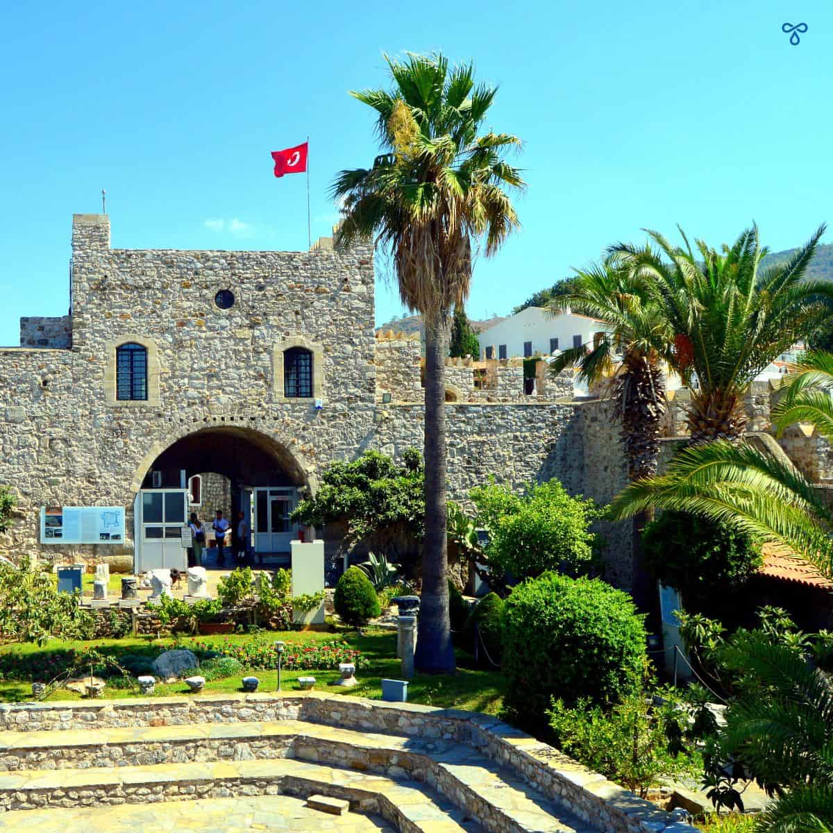Marmaris Castle entrance framed by palm trees.