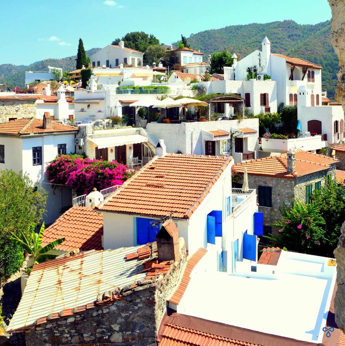 Whitewashed buildings with terracotta tiled roofs on a hillside.