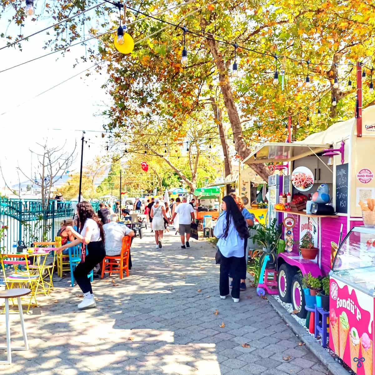 A pink and cerise street food van with people around it.