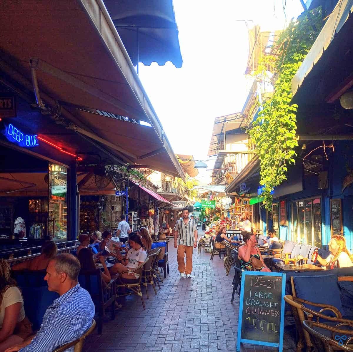 A shaded cobbled walkway in Fethiye's Paspatur. The seating and tables of Deep Blue Bar are either side of the path.