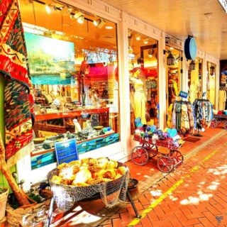 A shop front with goods presented in baskets and carts outside.