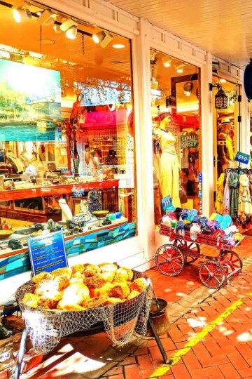 A shop front with goods presented in baskets and carts outside.