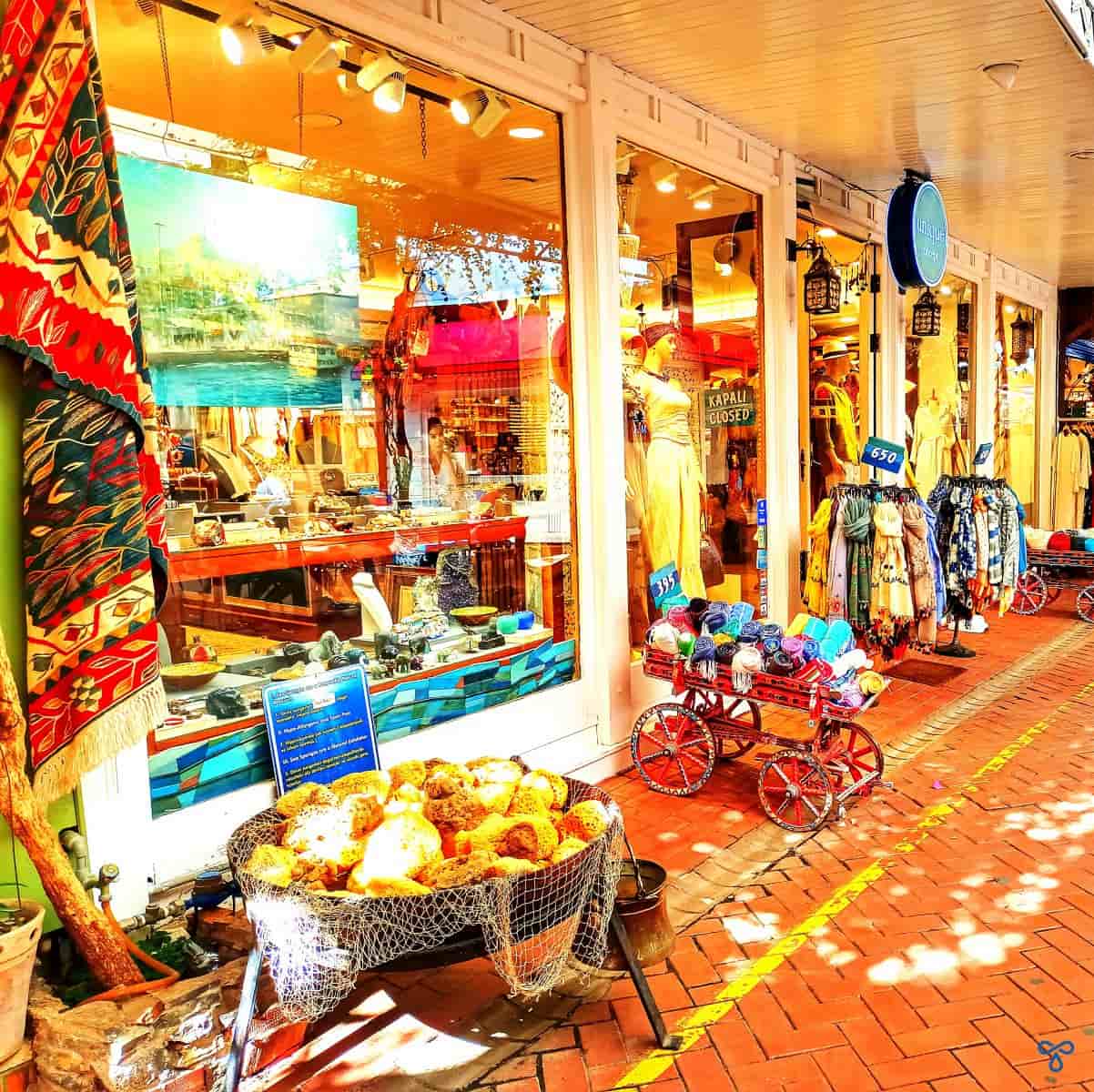 A colourful shop front with goods presented in baskets and carts outside.