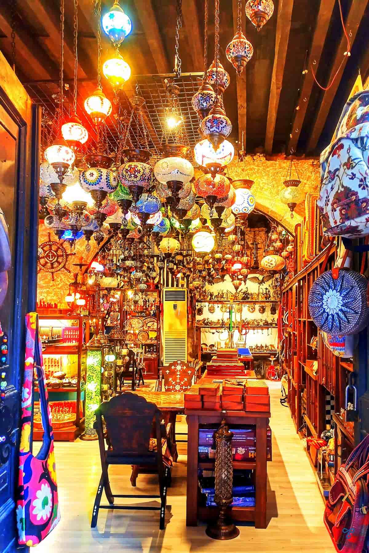 Looking into a souvenir shop in Fethiye old town. Mosiac lamps hang from the wooden beams on the ceiling.