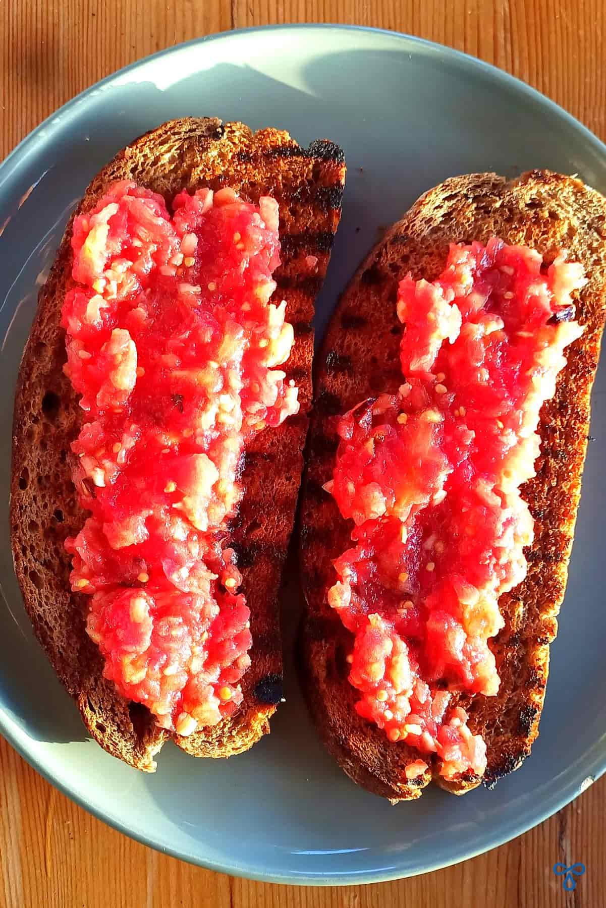 Two slices of griddled wholemeal bread with grated tomato over the top.