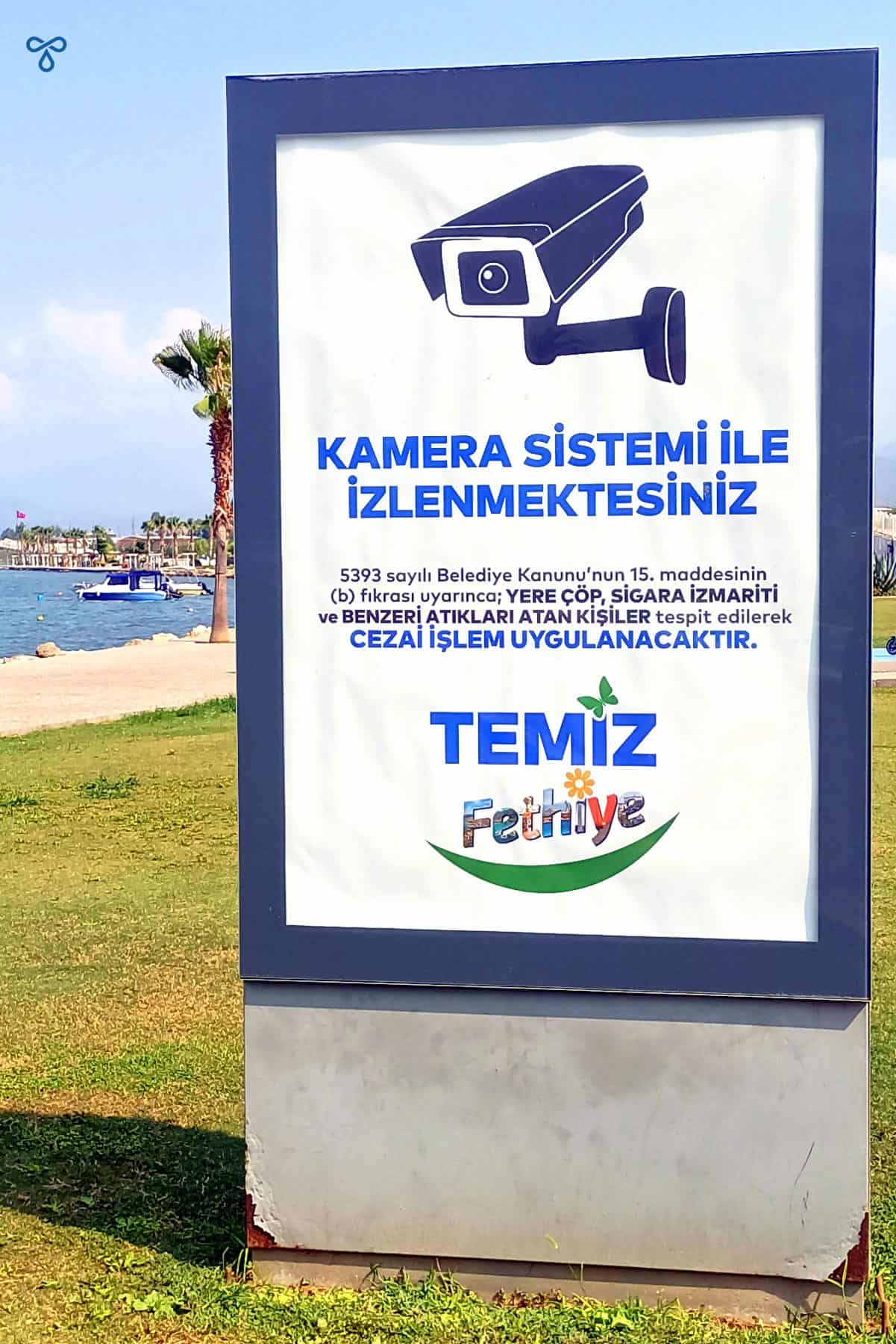 A poster with a CCTV camera and words telling people that fines will be issued to those caught littering.
