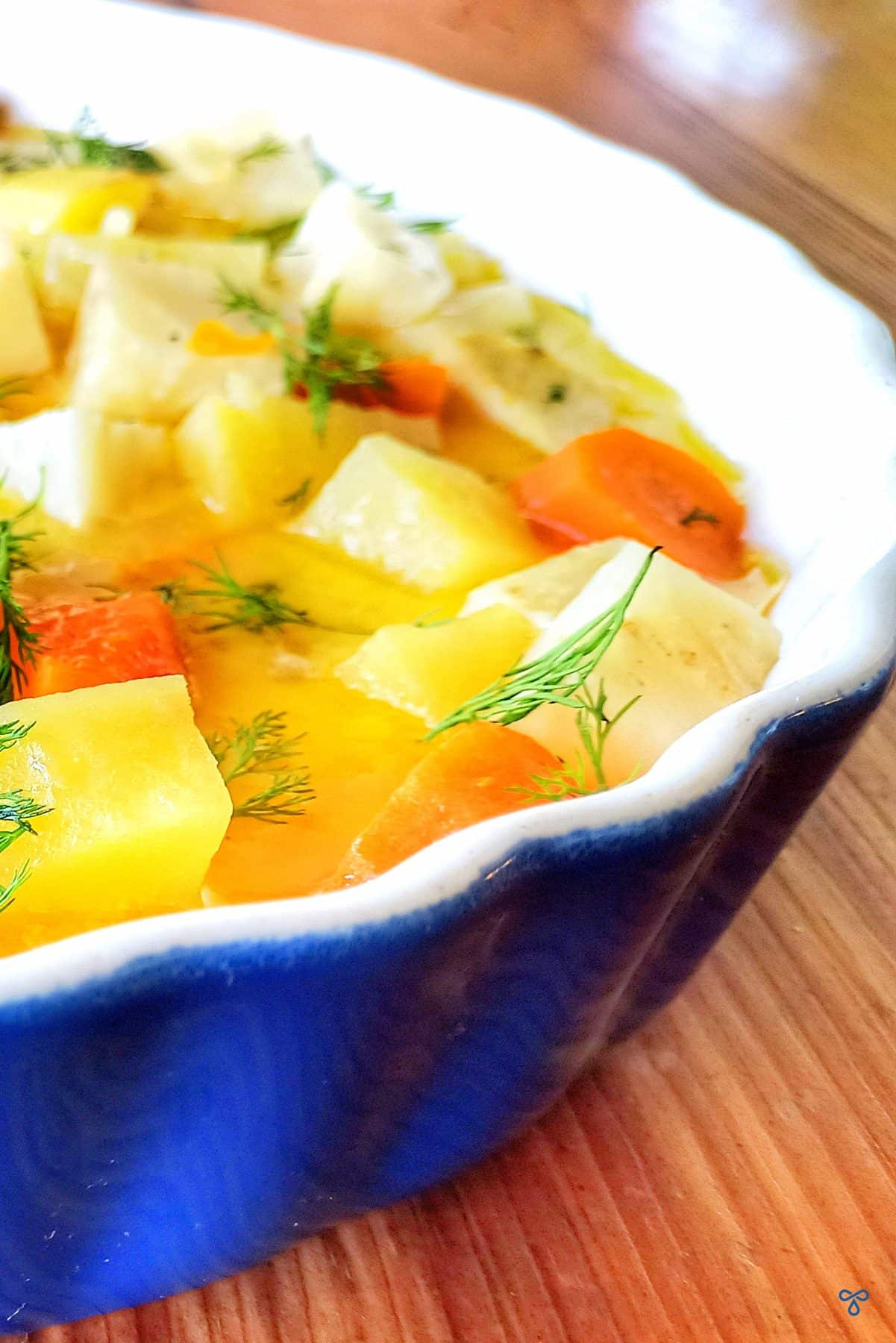 A close up of celeriac chunks with potato & carrot in olive oil & orange juice.