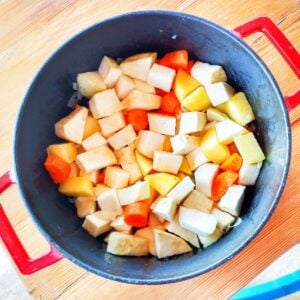 Chopped celeriac, potato and carrot in a pan, viewed from above.