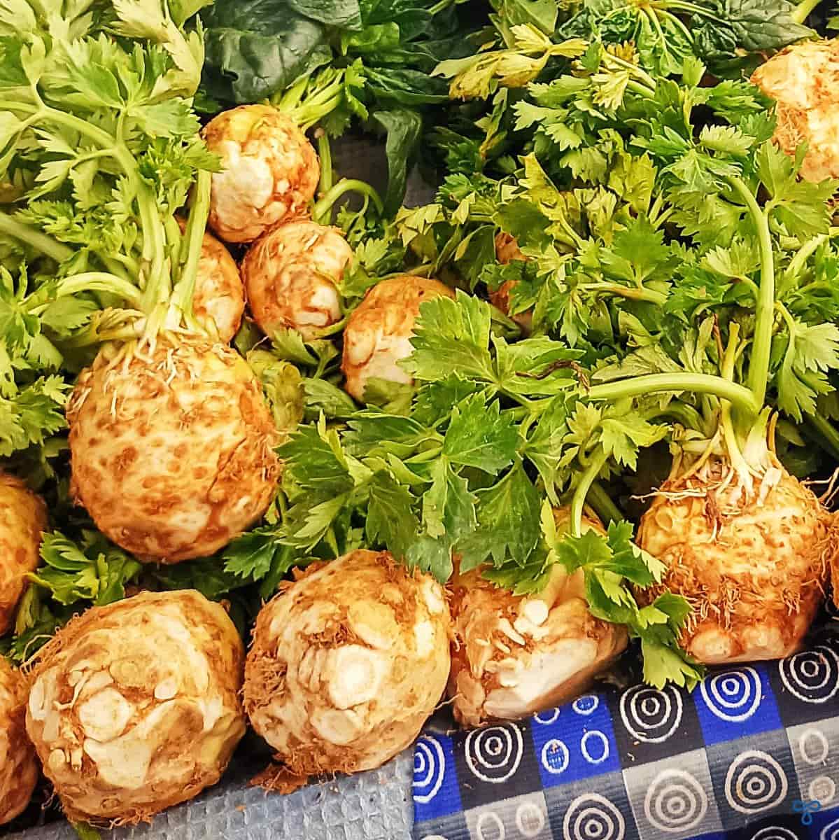 Celeriac with stalks and leaves on a market stall.
