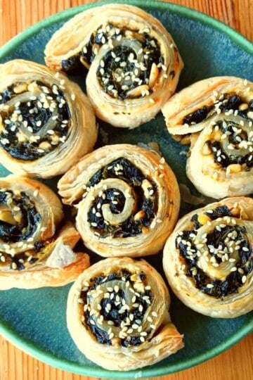Seven puff pastry pinwheels or swirls filled with spinach and a small amount of feta cheese.
