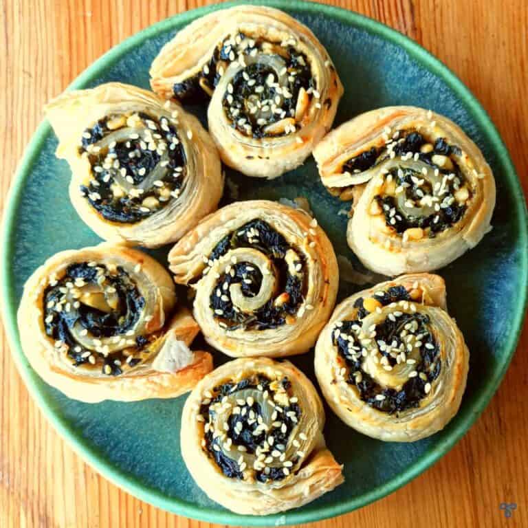 Seven puff pastry pinwheels or swirls filled with spinach and a small amount of feta cheese.